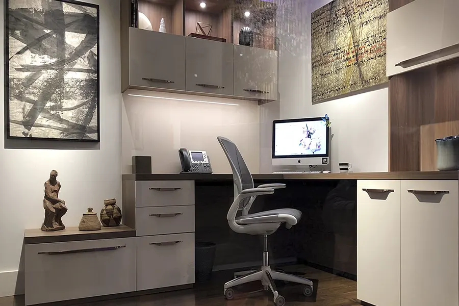 Custom home office with built-in storage, integrated lighting, glossy finishes, desk workspace, and modern organization solutions.