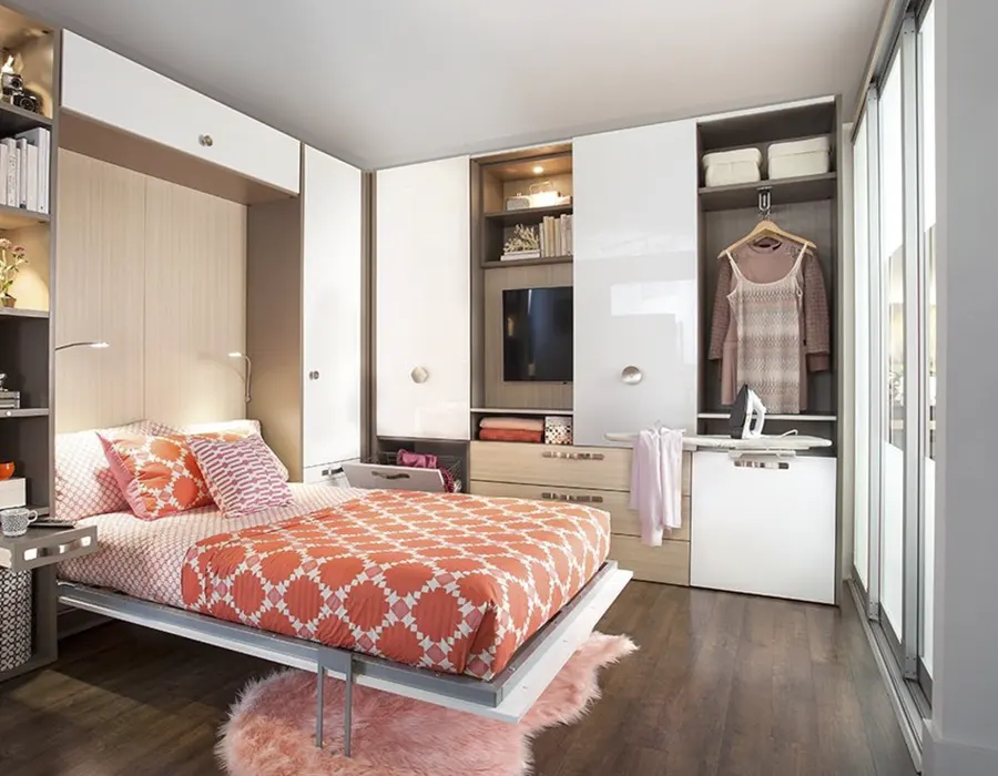 Custom Murphy bed with integrated wardrobe storage, tilt-out hamper, pull-out ironing board, shelving, and space-saving guest room design by Custom Closets A&G Designs.