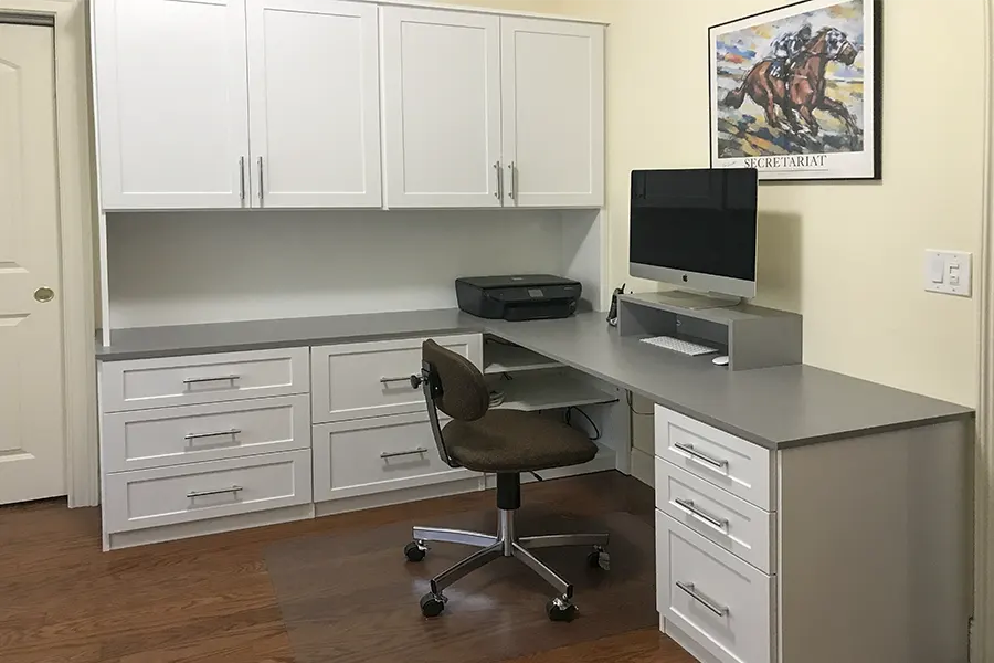 Custom home office featuring shaker style doors and drawer fronts, built-in desk, overhead storage cabinets, file drawers, and workspace organization by Custom Closets A&G Designs.
