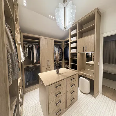 Walk-in closet woodgrain, center island drawers, open shelving, hanging clothes, and built-in vanity area.